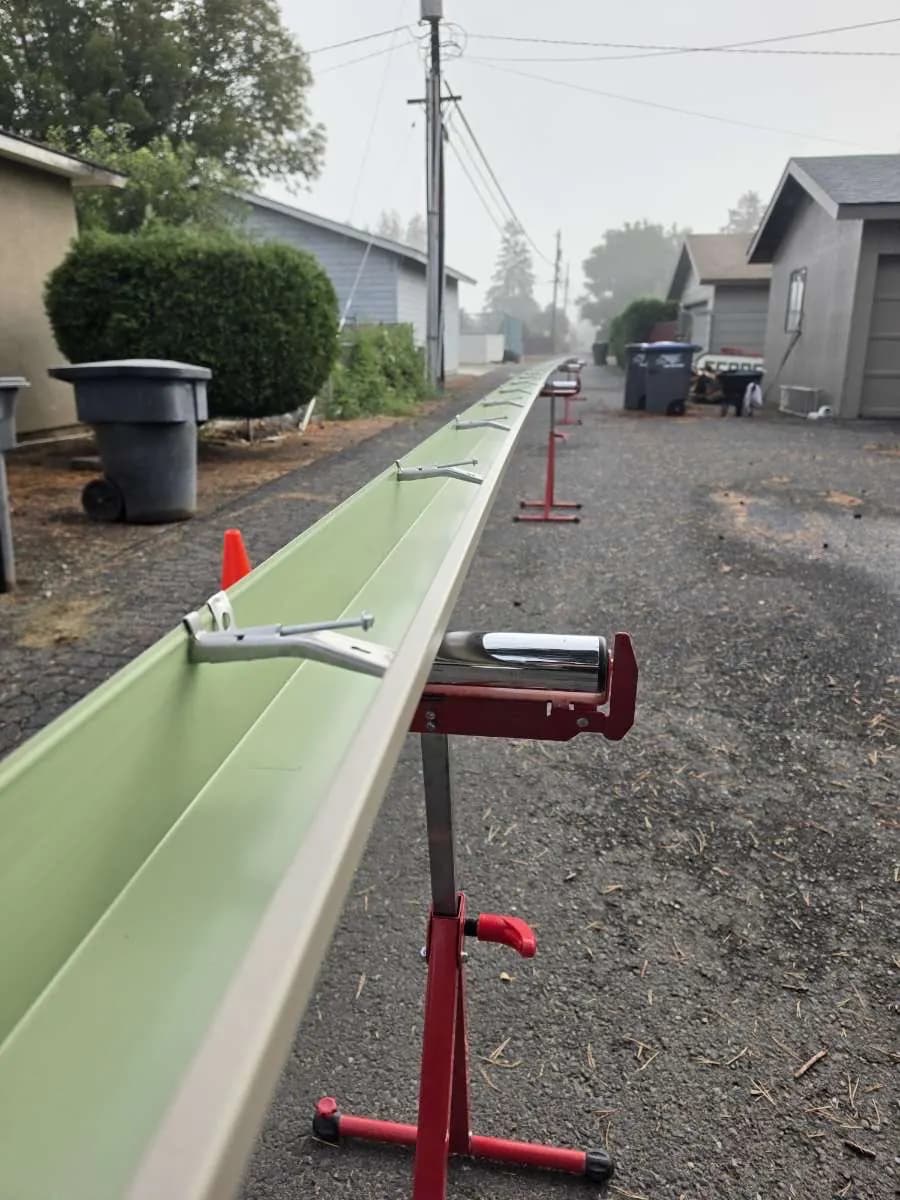 Close-up of a formed gutter with hidden hangers, resting on a roller stand
