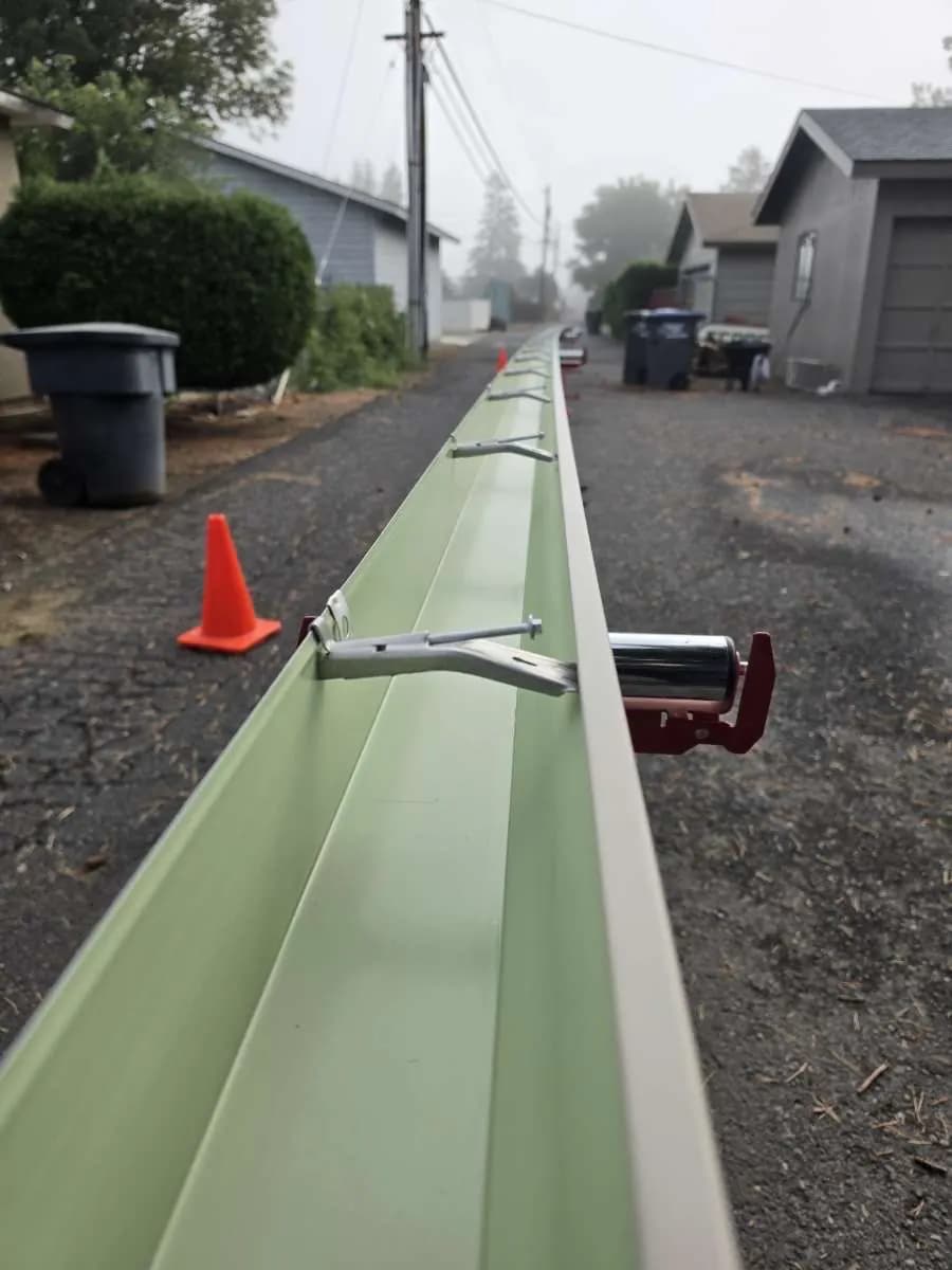Freshly formed gutter on a stand in a residential driveway