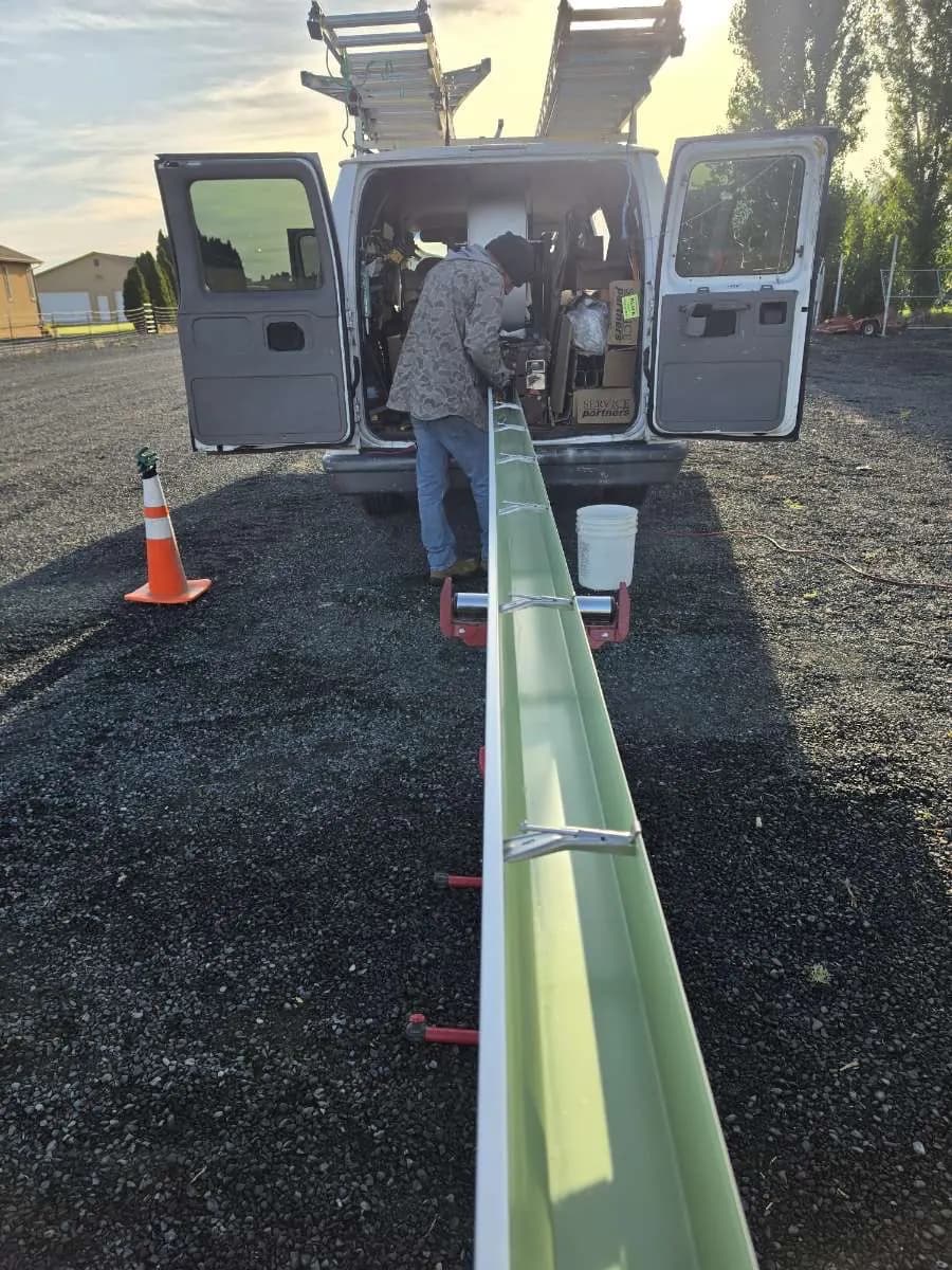 Crew running a gutter off the machine in the back of the van